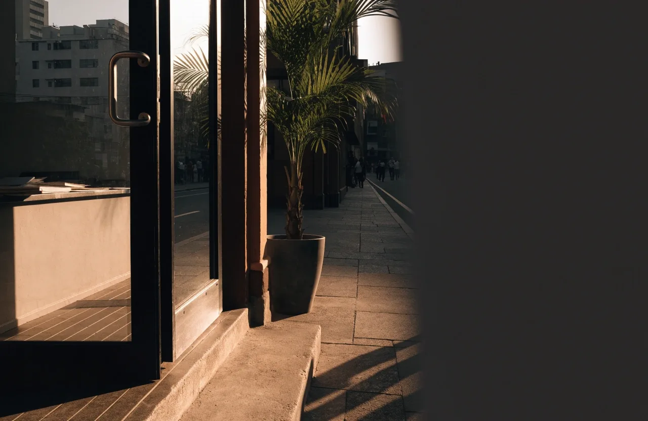 Street-level daylight view of the VitaMan Indo office entrance in Surabaya, shot at eye level toward the door jamb